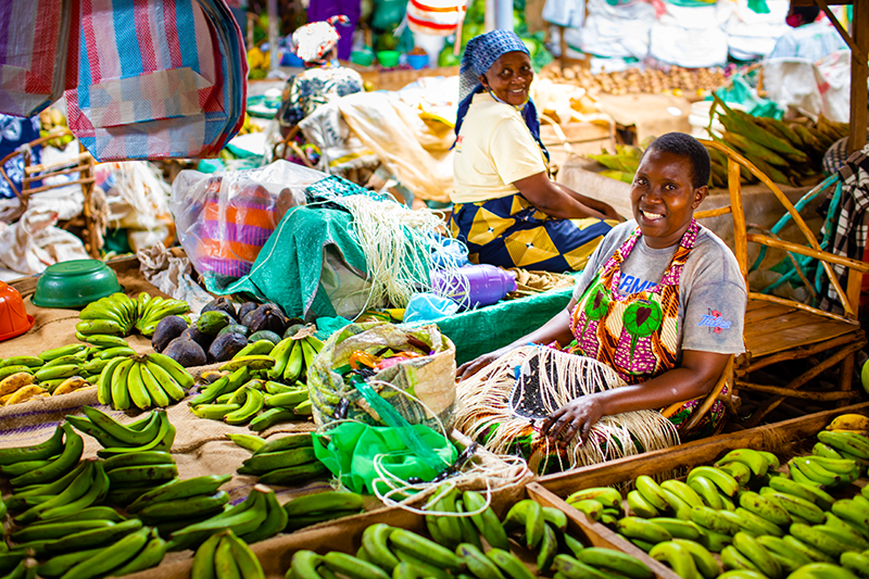 A woman selling bananas and other vegetables