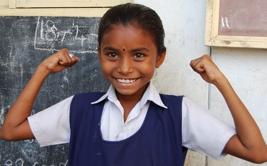 Little Indian girl raises her arms in show of strength 